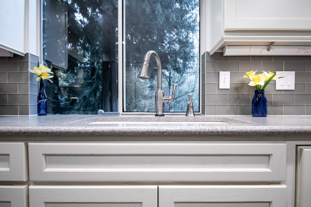 Transitional u-shaped medium tone wood floor open concept kitchen photo in Seattle with an undermount sink, shaker cabinets, white cabinets, quartz countertops, gray backsplash, glass tile backsplash, stainless steel appliances, a peninsula and multicolored countertops