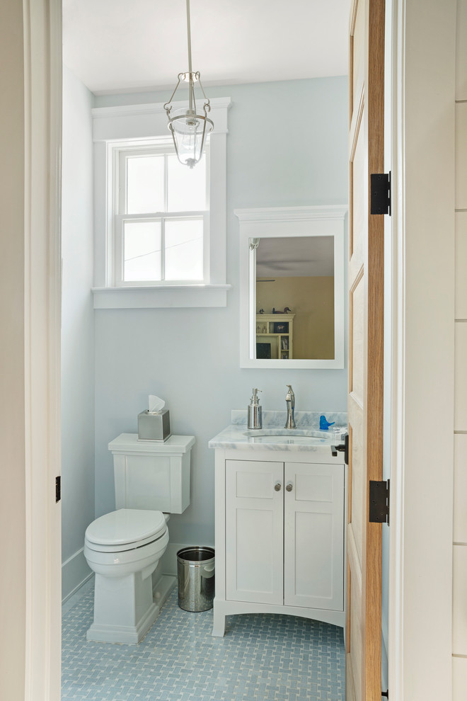 Beach style marble floor and gray floor powder room photo with furniture-like cabinets, white cabinets, gray walls, an undermount sink and white countertops