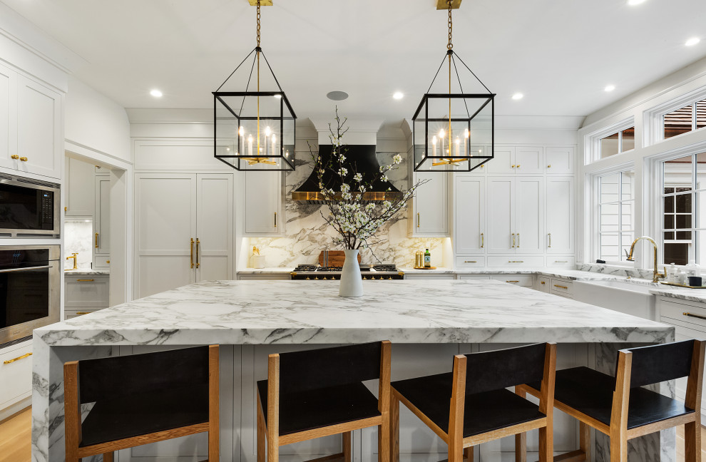 Inspiration for a huge transitional u-shaped kitchen remodel in New York with a farmhouse sink, shaker cabinets, white cabinets, gray backsplash, stainless steel appliances, an island and gray countertops