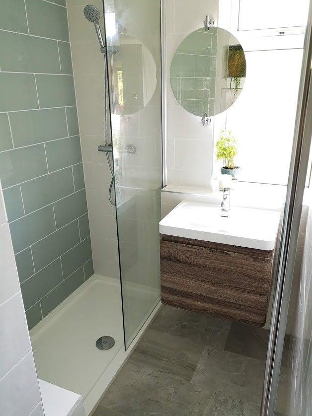 This is an example of a small contemporary kids bathroom in London with flat-panel cabinets, brown cabinets, an open shower, a one-piece toilet, green tile, porcelain tile, white walls, porcelain floors, an integrated sink, tile benchtops, grey floor, an open shower and white benchtops.