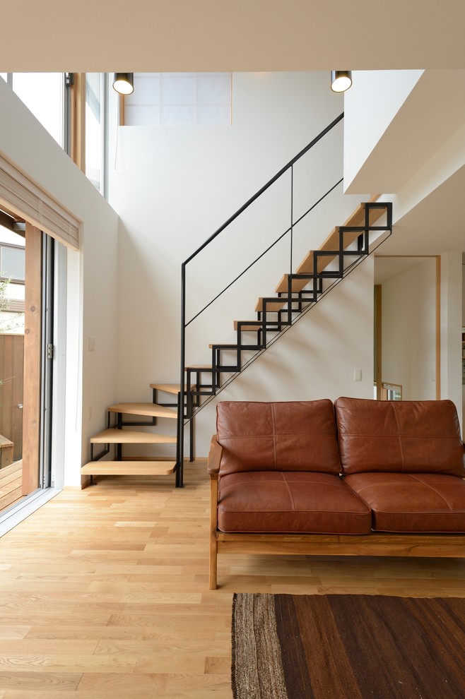 This is an example of a modern wood l-shaped staircase in Other with open risers and metal railing.