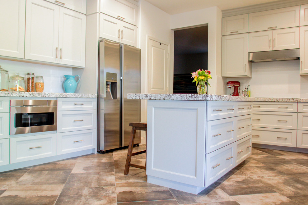 Eat-in kitchen - mid-sized transitional u-shaped porcelain tile and gray floor eat-in kitchen idea in Phoenix with a double-bowl sink, shaker cabinets, gray cabinets, granite countertops, white backsplash, subway tile backsplash, stainless steel appliances, an island and white countertops