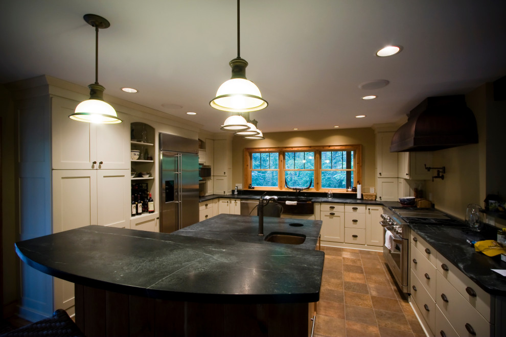 Example of a large u-shaped ceramic tile and brown floor kitchen design with a single-bowl sink, flat-panel cabinets, white cabinets, an island and black countertops