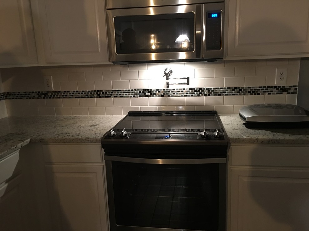 Large transitional galley ceramic tile eat-in kitchen photo with an undermount sink, raised-panel cabinets, dark wood cabinets, granite countertops, stainless steel appliances, no island, white backsplash and subway tile backsplash