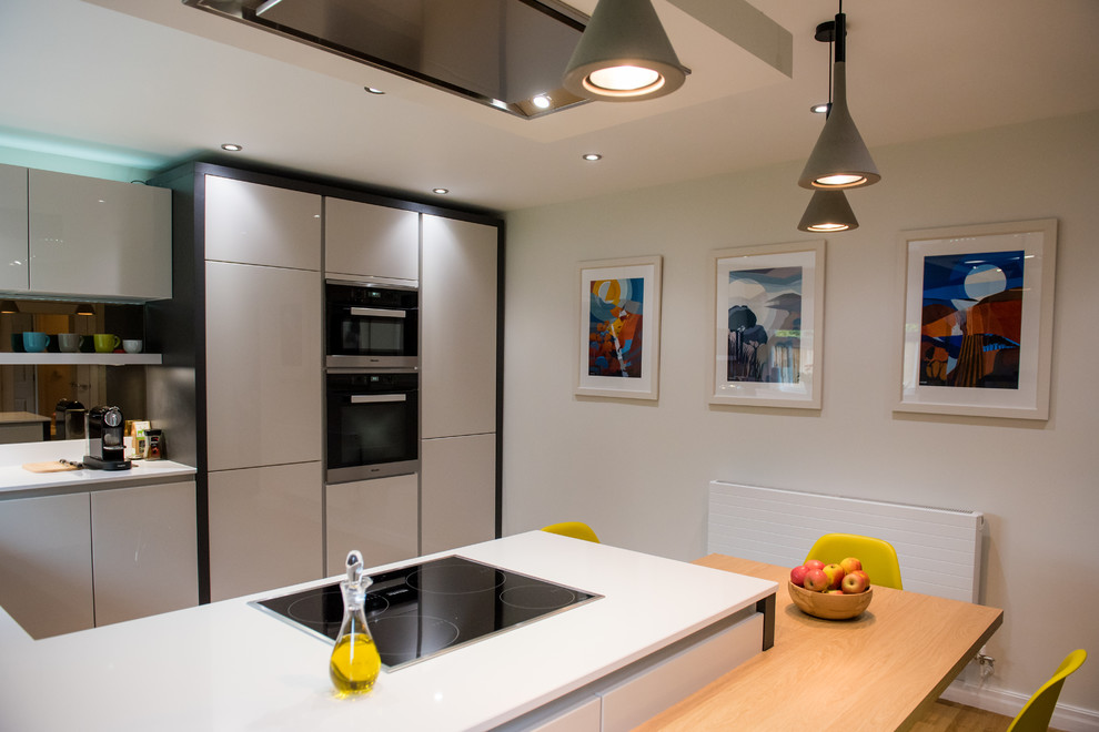 This is an example of a mid-sized contemporary eat-in kitchen in Other with quartzite benchtops, mirror splashback and no island.