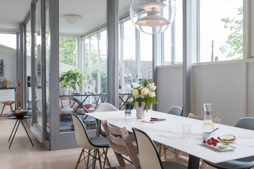 This is an example of a mid-sized contemporary open plan dining in Berlin with light hardwood floors, white walls and brown floor.