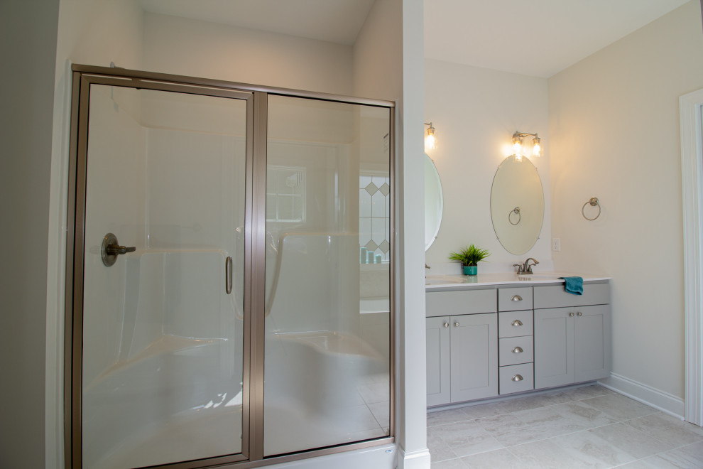 Exempel på ett stort amerikanskt vit vitt en-suite badrum, med luckor med infälld panel, grå skåp, ett badkar i en alkov, en dusch i en alkov, en toalettstol med separat cisternkåpa, vita väggar, klinkergolv i keramik, ett integrerad handfat, vitt golv och dusch med gångjärnsdörr