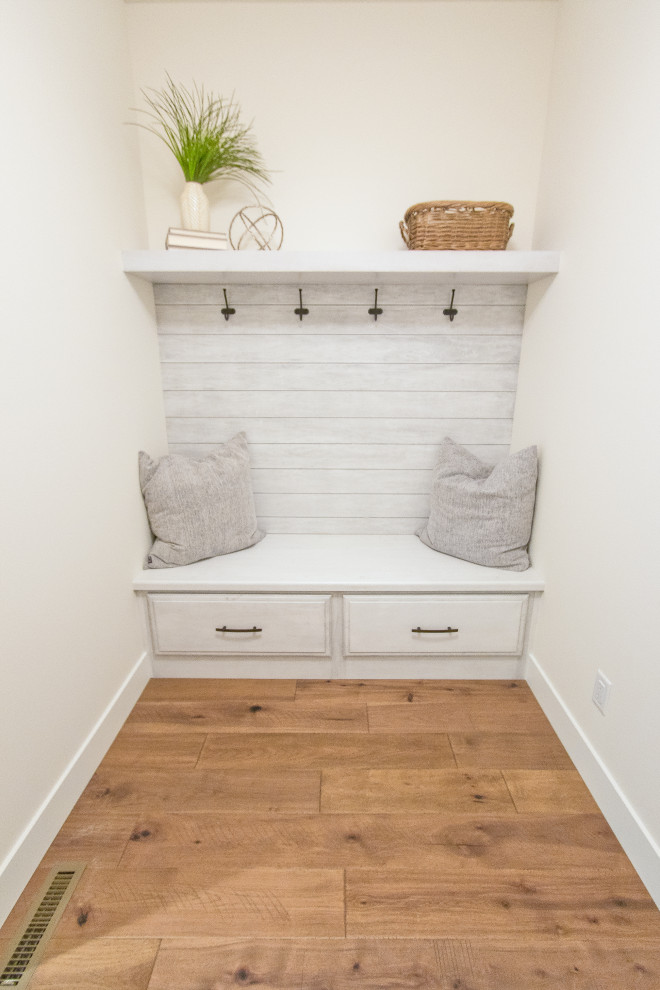 Transitional light wood floor and brown floor entryway photo with white walls