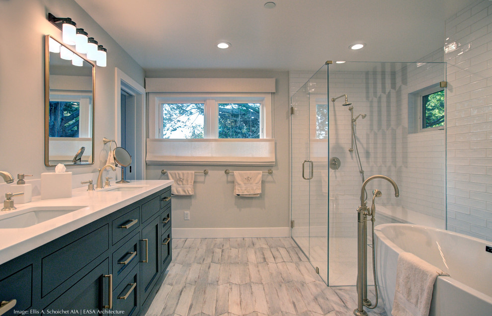 Photo of a large traditional ensuite bathroom in San Francisco with recessed-panel cabinets, black cabinets, a freestanding bath, a built-in shower, white tiles, metro tiles, white walls, marble flooring, a submerged sink, engineered stone worktops, white floors, a hinged door, white worktops, a shower bench, double sinks, a built in vanity unit and wainscoting.