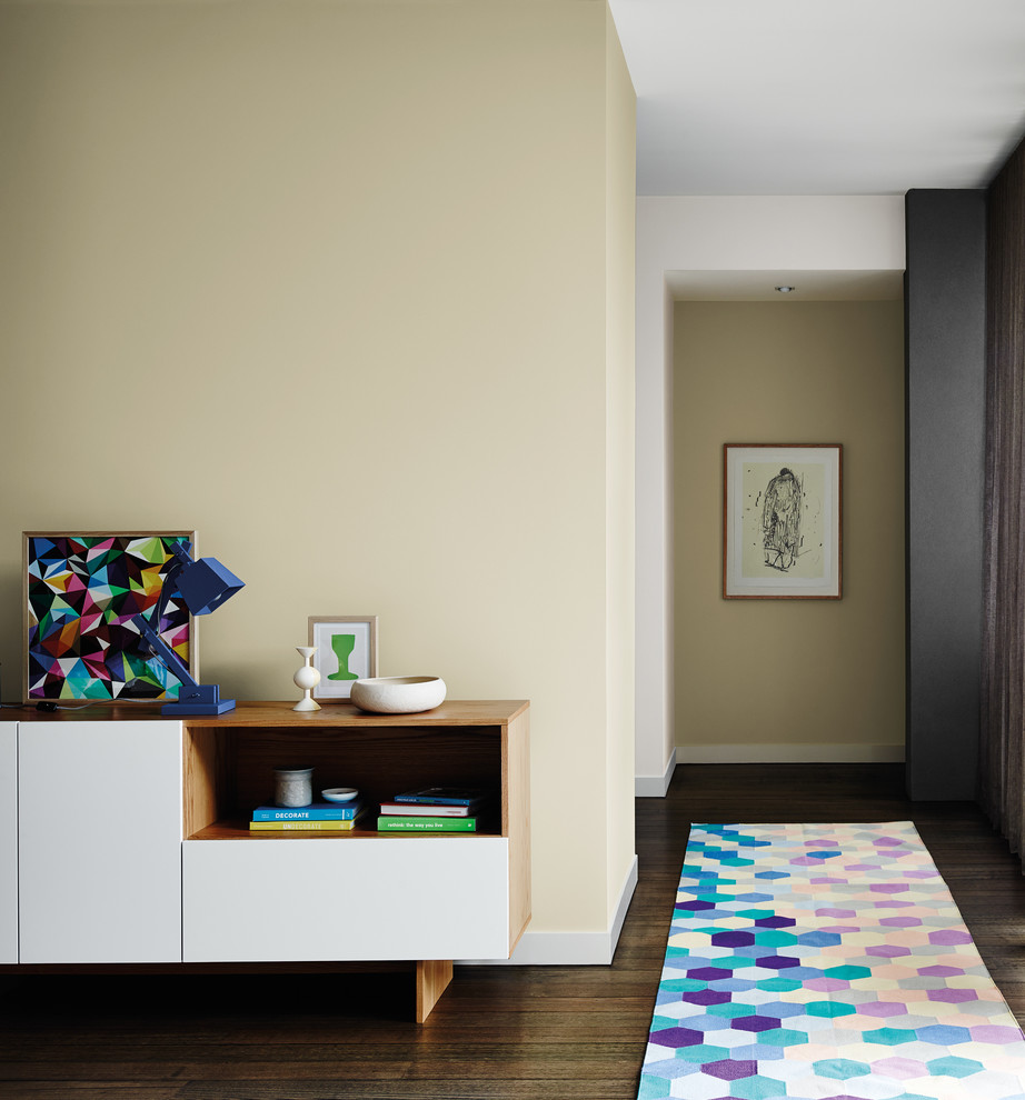 This is an example of a small contemporary hallway in Melbourne with beige walls and dark hardwood floors.