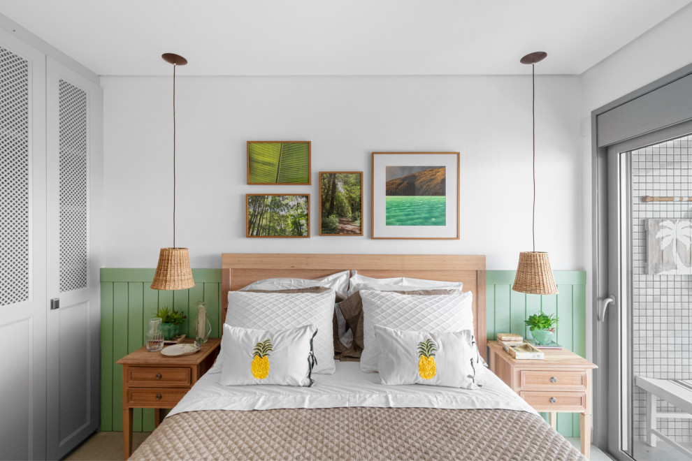 This is an example of a tropical bedroom with white walls and decorative wall panelling.
