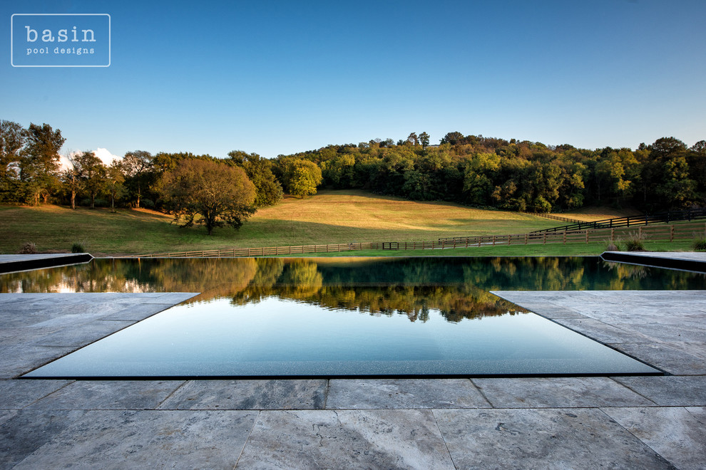 Example of a large transitional backyard stone and custom-shaped infinity hot tub design in Nashville