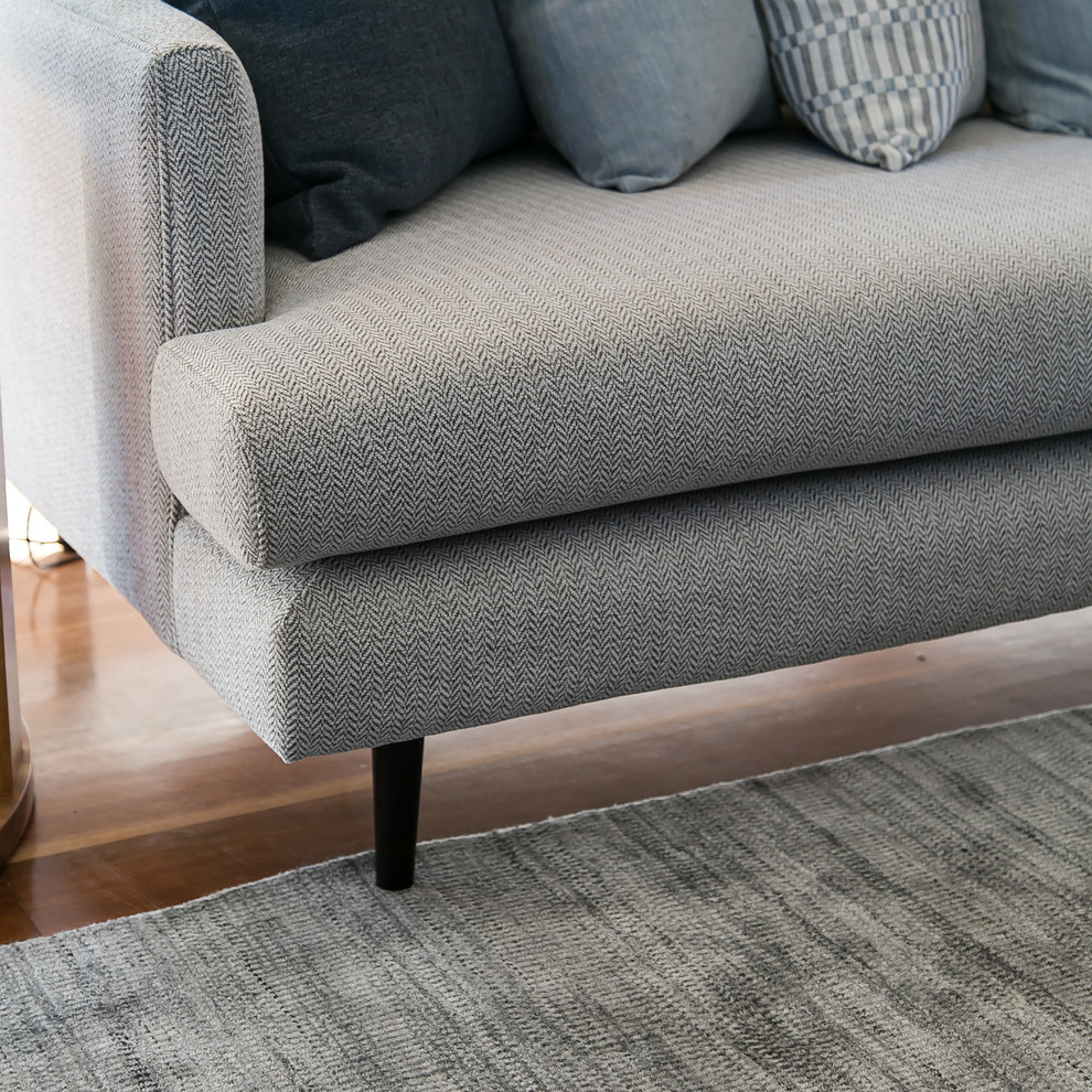 This is an example of a large contemporary living room in Melbourne with white walls, medium hardwood floors and brown floor.