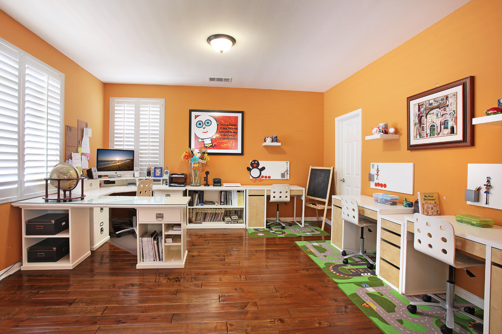 This is an example of a transitional home office in Orange County with orange walls.