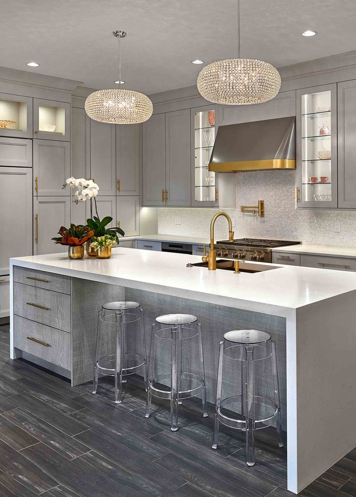 This is an example of an expansive contemporary l-shaped eat-in kitchen in Bridgeport with a single-bowl sink, recessed-panel cabinets, grey cabinets, marble benchtops, metallic splashback, mosaic tile splashback, stainless steel appliances, dark hardwood floors, with island, grey floor and white benchtop.