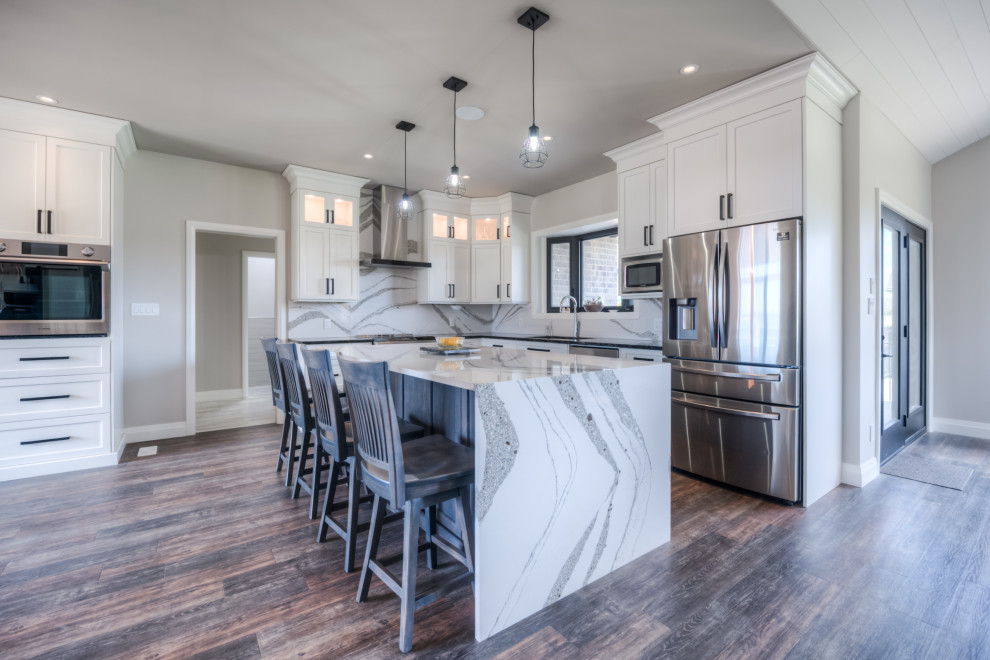 Inspiration for a transitional eat-in kitchen remodel with shaker cabinets, white cabinets, stainless steel appliances and an island