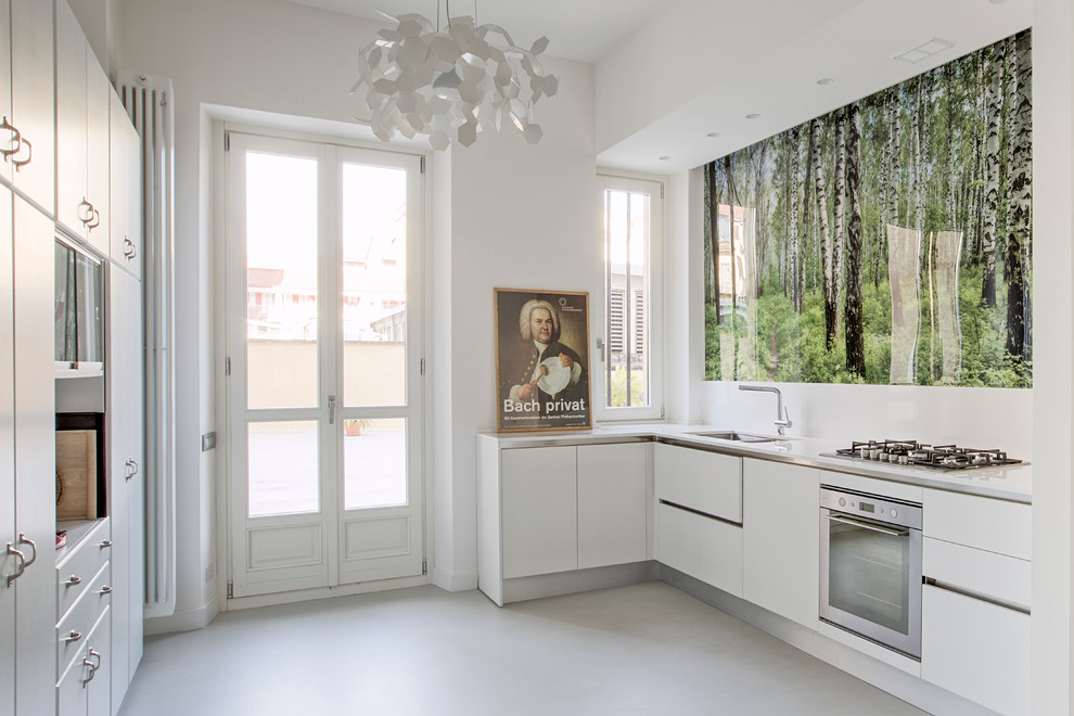 Photo of a contemporary kitchen in Turin with an undermount sink, flat-panel cabinets, white cabinets, stainless steel appliances and no island.