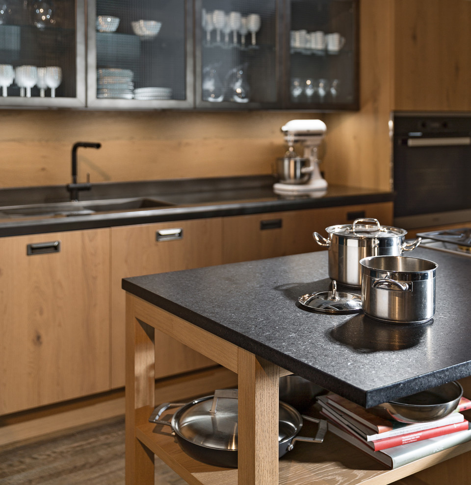 Eat-in kitchen - mid-sized modern galley dark wood floor eat-in kitchen idea in Detroit with an undermount sink, flat-panel cabinets, distressed cabinets, granite countertops, brown backsplash, black appliances and an island