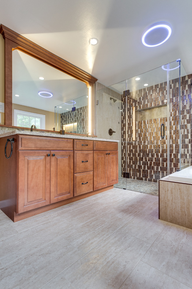 This is an example of a large traditional master bathroom in DC Metro with raised-panel cabinets, medium wood cabinets, a corner tub, a corner shower, a two-piece toilet, beige tile, brown tile, ceramic tile, beige walls, bamboo floors, an undermount sink and granite benchtops.