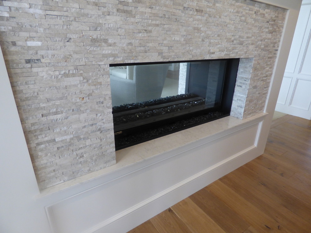Example of a large transitional l-shaped light wood floor eat-in kitchen design with an undermount sink, recessed-panel cabinets, white cabinets, quartz countertops, white backsplash, subway tile backsplash, stainless steel appliances and an island