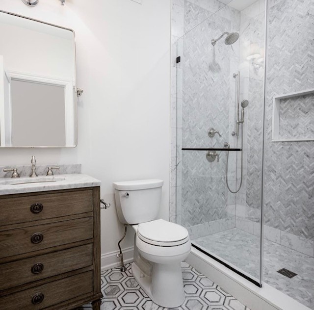 Photo of a transitional bathroom in Philadelphia with an alcove shower, a one-piece toilet, gray tile, marble, white walls, marble floors, an undermount sink, grey floor, a sliding shower screen and grey benchtops.