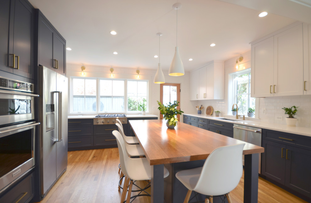 Inspiration for a large transitional u-shaped medium tone wood floor and beige floor kitchen remodel in DC Metro with an undermount sink, shaker cabinets, blue cabinets, white backsplash, stainless steel appliances, an island and white countertops