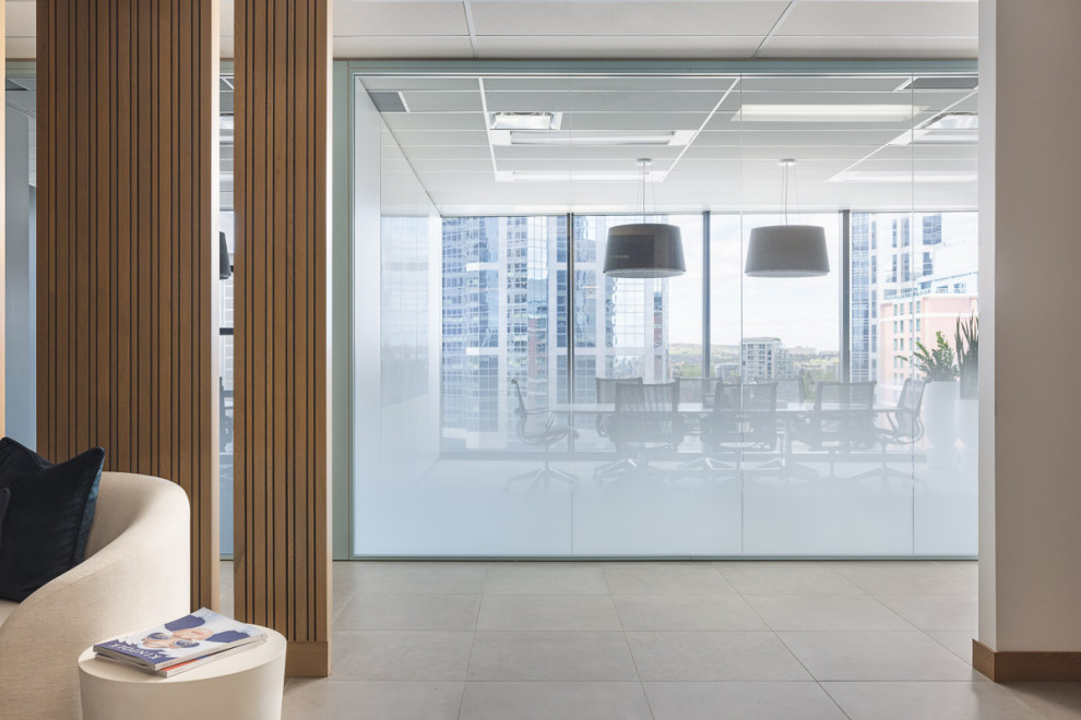На фото: большой кабинет в современном стиле с серыми стенами, отдельно стоящим рабочим столом, серым полом и панелями на части стены