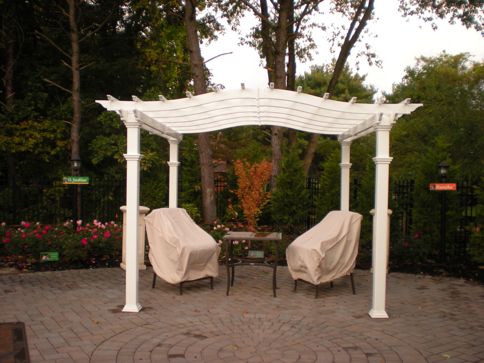 Photo of an expansive traditional backyard patio in New York with a water feature, concrete pavers and a pergola.