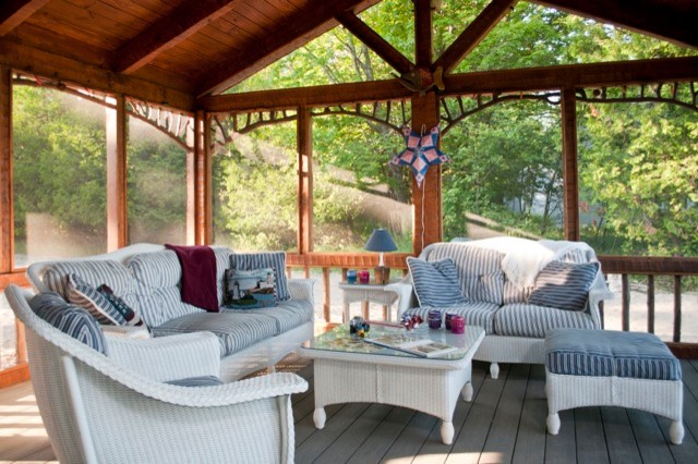 This is an example of a mid-sized country screened-in verandah in Other with decking and a roof extension.