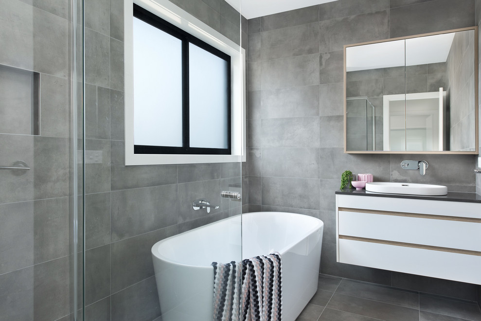 Contemporary bathroom in Canberra - Queanbeyan with flat-panel cabinets, white cabinets, a freestanding tub, gray tile, a drop-in sink, grey floor and grey benchtops.