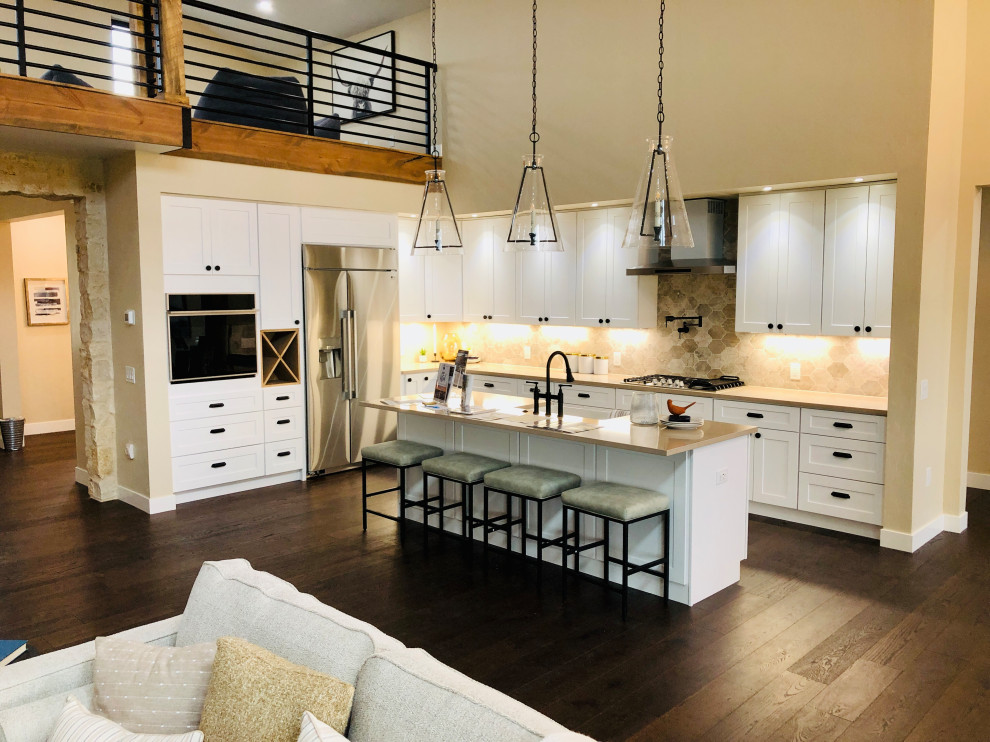 Large contemporary l-shaped eat-in kitchen in Denver with a farmhouse sink, shaker cabinets, white cabinets, stainless steel appliances and with island.