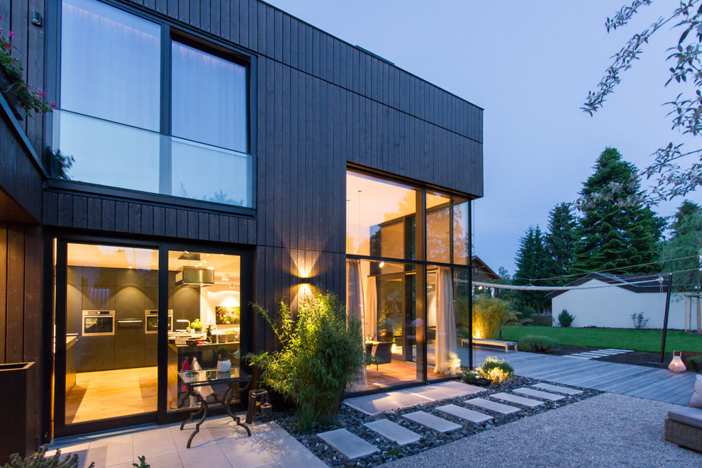 This is an example of a mid-sized contemporary backyard deck in Munich with no cover.