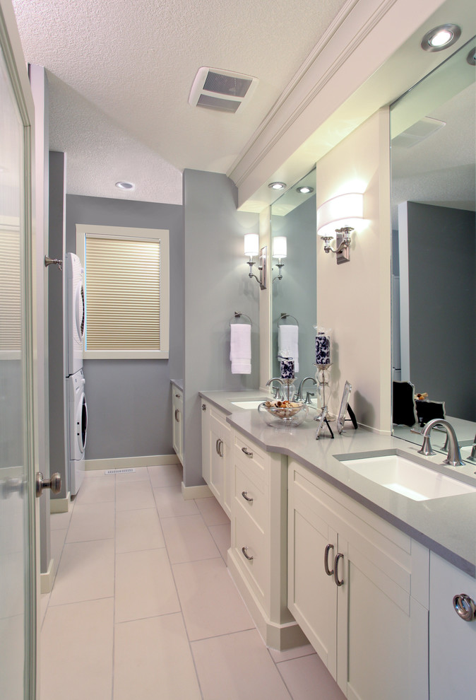Photo of a transitional bathroom in Calgary with shaker cabinets, white tile, white cabinets, an alcove shower, grey walls, porcelain floors, an undermount sink and engineered quartz benchtops.