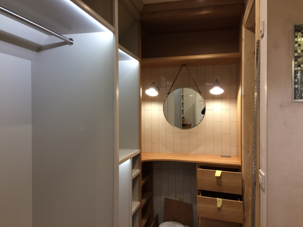 Photo of a small contemporary women's dressing room in Gloucestershire with open cabinets, grey cabinets, dark hardwood floors and brown floor.