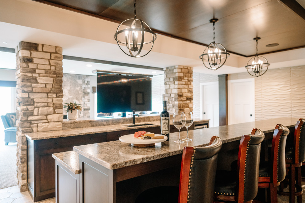 This is an example of a mid-sized transitional galley wet bar in Cedar Rapids with an undermount sink, shaker cabinets, brown cabinets, granite benchtops and granite splashback.