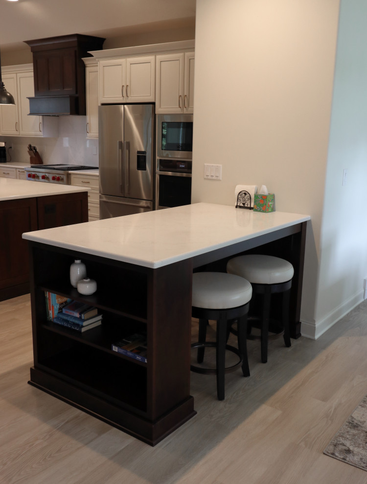Large transitional l-shaped kitchen photo with an undermount sink, recessed-panel cabinets, quartz countertops, white backsplash, quartz backsplash, stainless steel appliances and white countertops