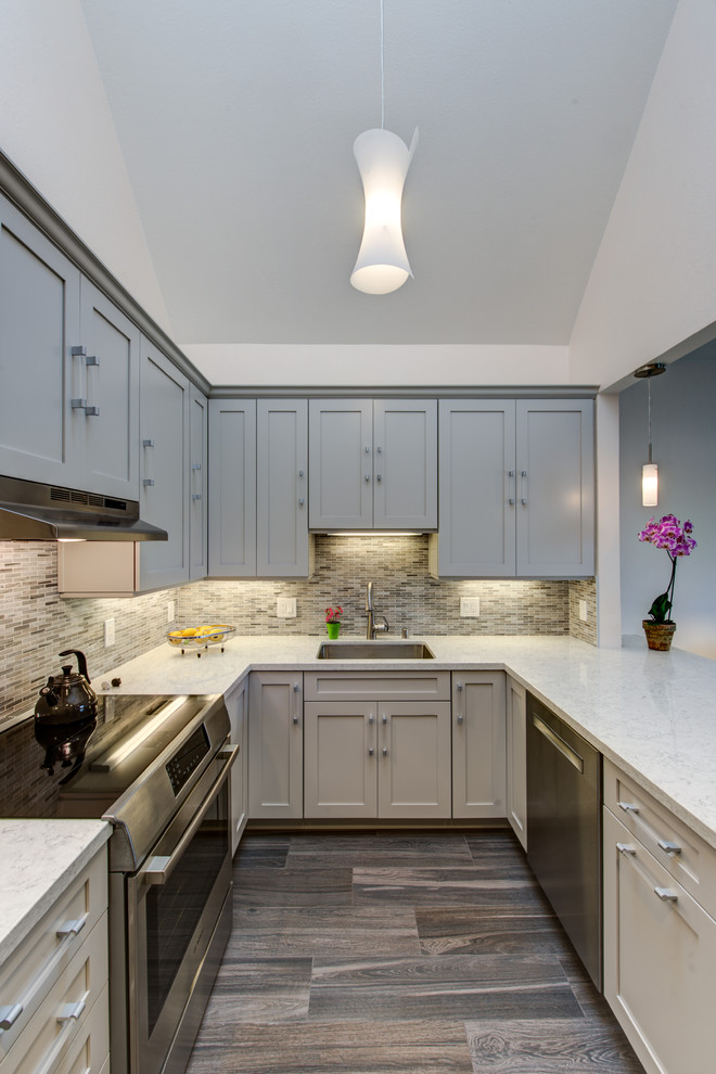Inspiration for a mid-sized transitional u-shaped kitchen in San Francisco with an undermount sink, shaker cabinets, grey cabinets, stainless steel appliances, a peninsula, quartz benchtops, dark hardwood floors, multi-coloured splashback and mosaic tile splashback.