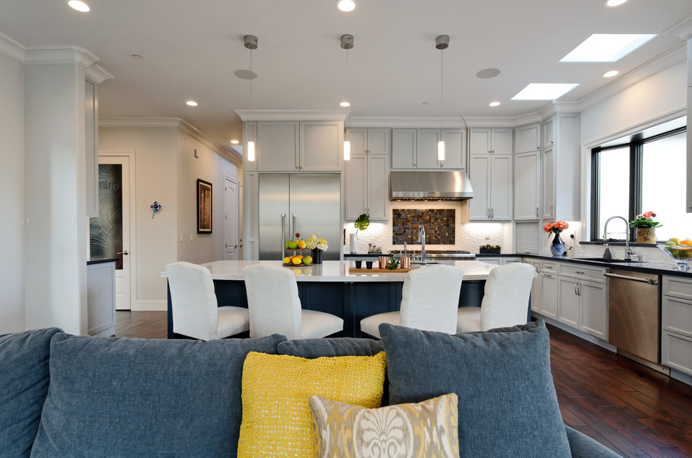 Example of a large transitional u-shaped dark wood floor and brown floor eat-in kitchen design in San Francisco with an undermount sink, recessed-panel cabinets, gray cabinets, quartz countertops, white backsplash, ceramic backsplash, stainless steel appliances, an island and white countertops