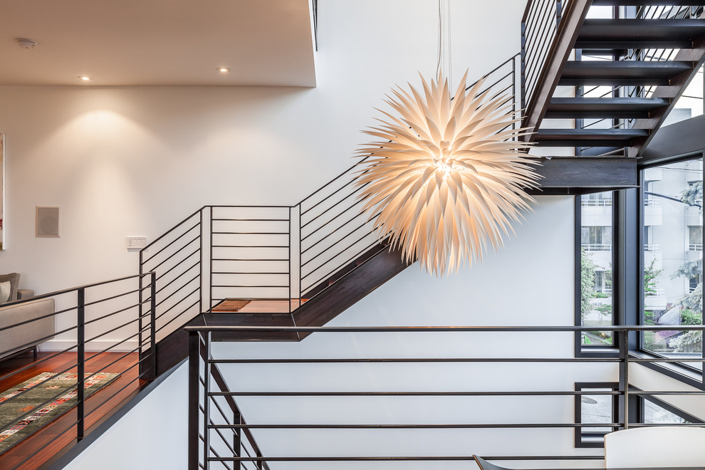 Photo of a large contemporary wood floating staircase in Seattle with metal risers.