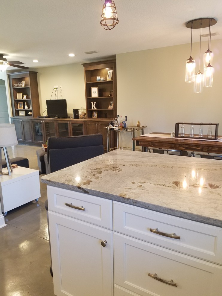 Photo of a small industrial u-shaped open plan kitchen in Jacksonville with white cabinets, quartzite benchtops, concrete floors, a peninsula, grey floor, a double-bowl sink, recessed-panel cabinets, white splashback, subway tile splashback and stainless steel appliances.