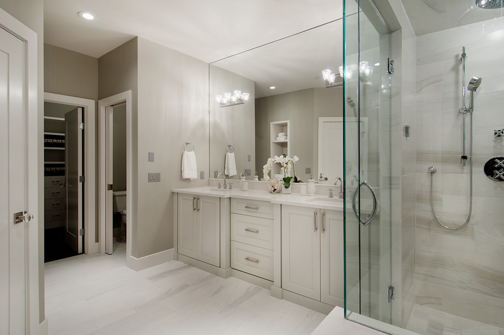 Photo of a transitional bathroom in Calgary with an undermount sink, flat-panel cabinets, white cabinets, quartzite benchtops, a drop-in tub, a corner shower, white tile, porcelain tile, grey walls and porcelain floors.