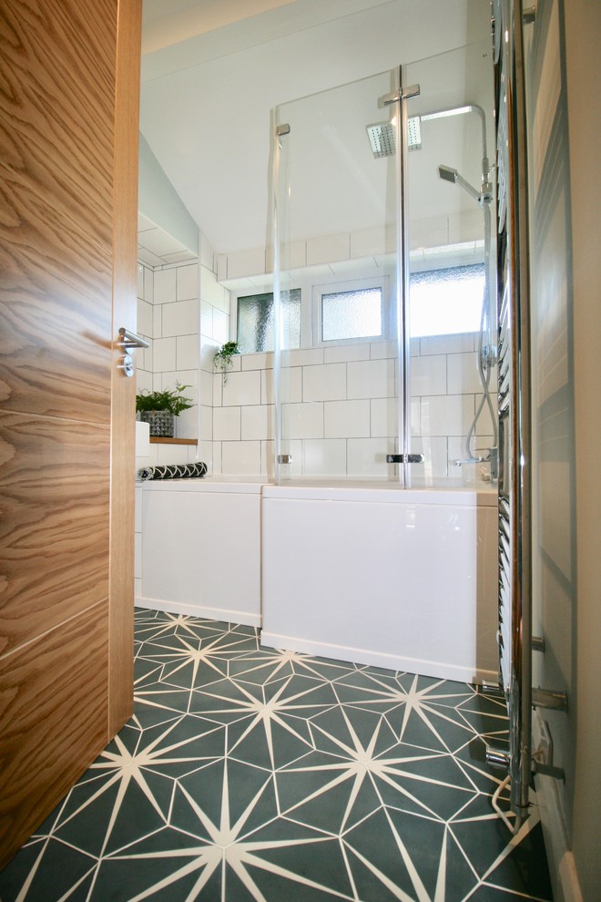 Inspiration for a small contemporary kids bathroom in Other with flat-panel cabinets, white cabinets, a drop-in tub, a shower/bathtub combo, a one-piece toilet, white tile, ceramic tile, blue walls, cement tiles, an integrated sink, wood benchtops, blue floor, a hinged shower door and beige benchtops.