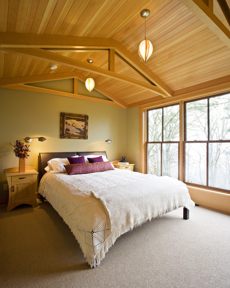 This is an example of a contemporary master bedroom in Portland with beige walls and carpet.