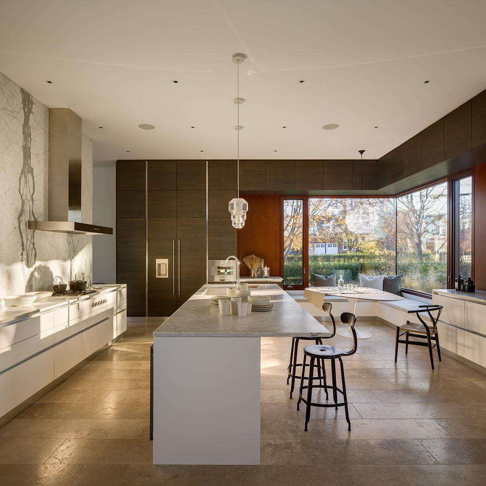 Large modern u-shaped eat-in kitchen in New York with limestone floors, with island, an undermount sink, beige floor, flat-panel cabinets, white cabinets, marble benchtops, white splashback, stone slab splashback and panelled appliances.