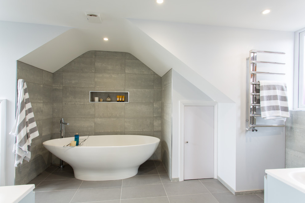 Medium sized contemporary ensuite bathroom in London with flat-panel cabinets, grey cabinets, a freestanding bath, grey tiles, ceramic tiles, white walls and ceramic flooring.