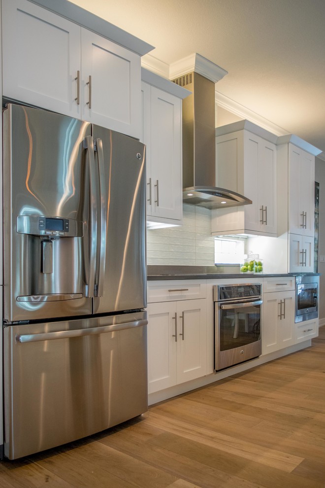 Open concept kitchen - mid-sized transitional single-wall light wood floor and beige floor open concept kitchen idea in Miami with shaker cabinets, white cabinets, marble countertops, white backsplash, stainless steel appliances, an island, an undermount sink and subway tile backsplash