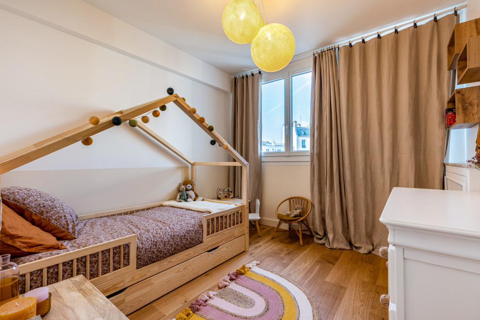 Exempel på ett mellanstort retro könsneutralt barnrum kombinerat med sovrum och för 4-10-åringar, med beige väggar, ljust trägolv och brunt golv