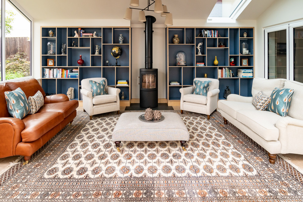 This is an example of a traditional living room with beige walls, a wood burning stove, beige floors and a vaulted ceiling.