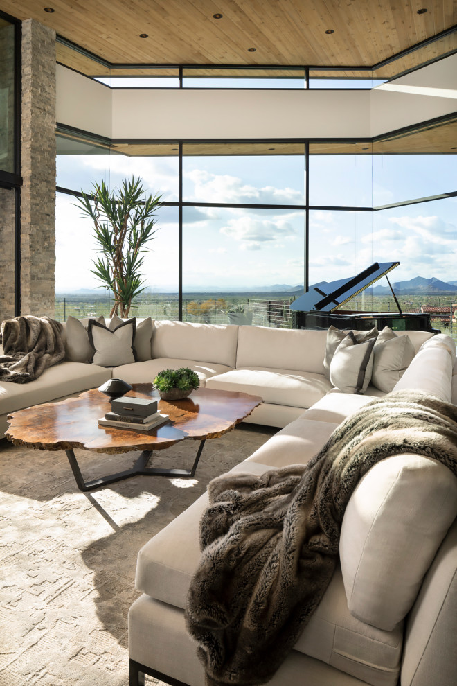 This is an example of an expansive modern open concept living room in Phoenix with a music area, a two-sided fireplace, a stone fireplace surround and wood.