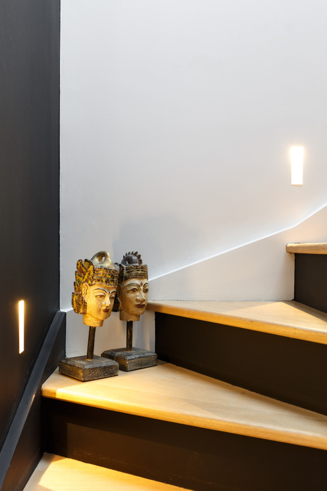 Inspiration for a large contemporary wood u-shaped staircase in Paris with painted wood risers and wood railing.